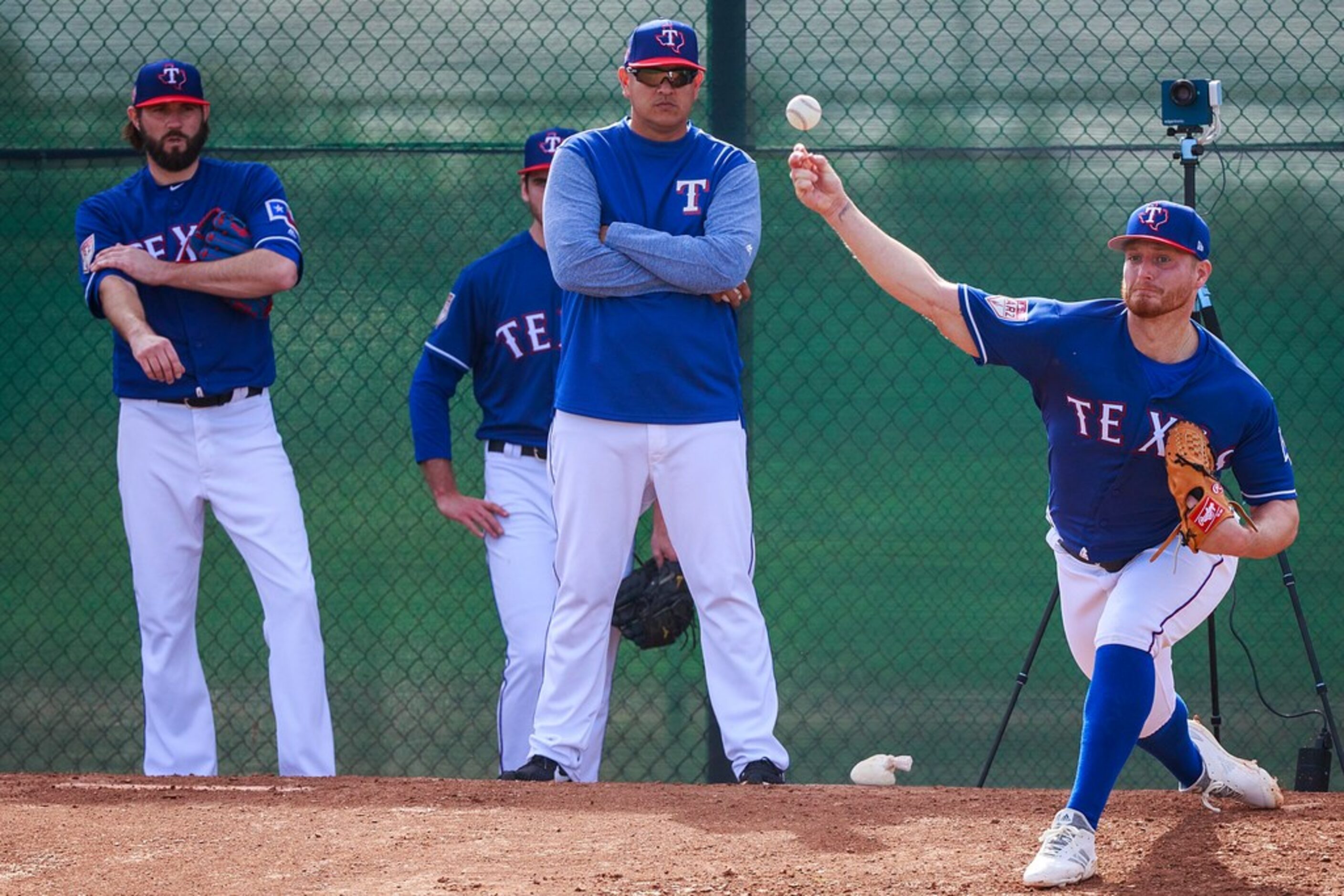 Texas Rangers pitcher Shelby Miller throws in the bullpen as pitching coach Julio Rangel...