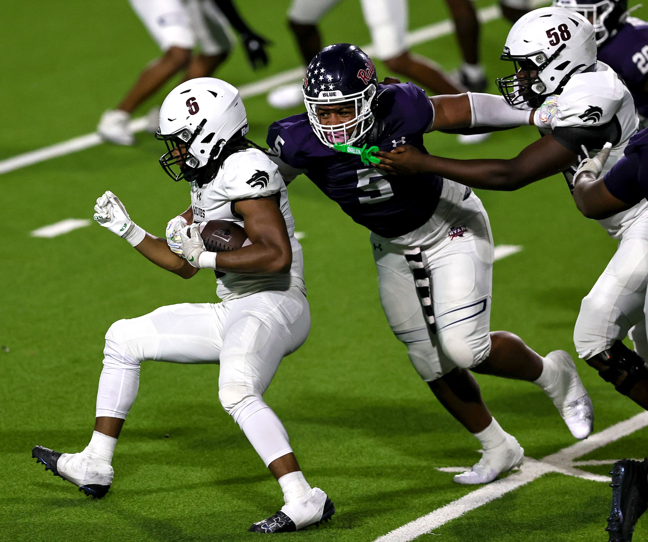 Mansfield Timberview running back Jaylon Woods (6) tries to break a tackle from Denton Ryan...