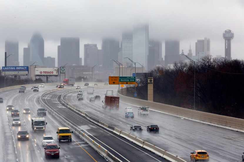 Motorists drive in the rain on Interstate I-35 south of downtown Dallas.