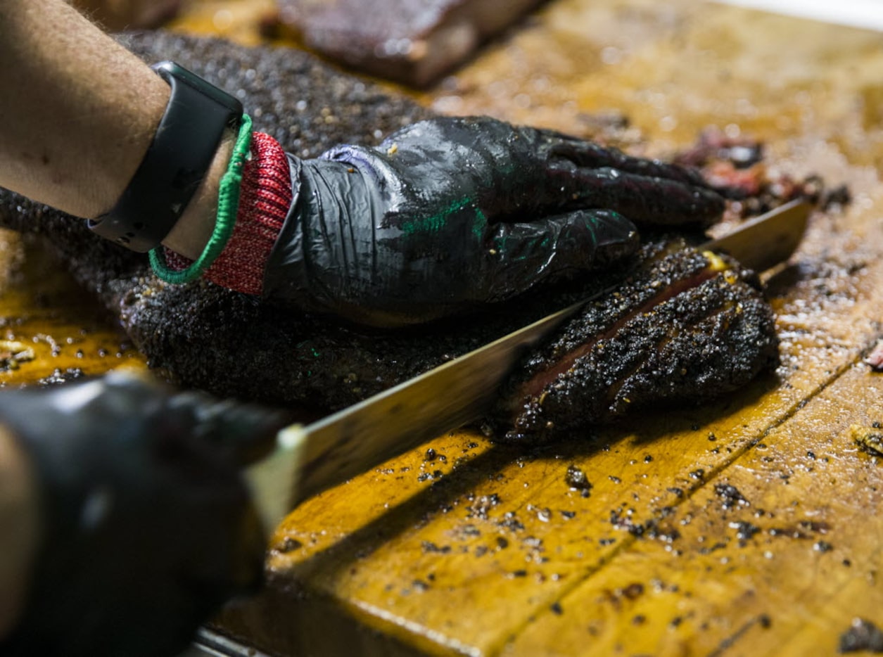 Owner and pitmaster Todd David slices brisket for customers on Friday, December 11, 2015 at...