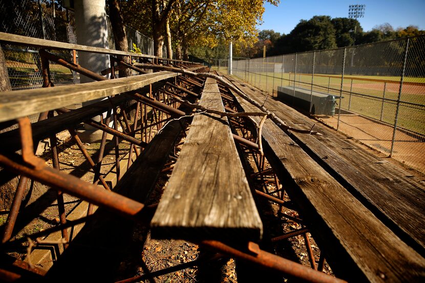 The old first- and third-base wood-clad bleachers at the Reverchon ball field are barricaded...