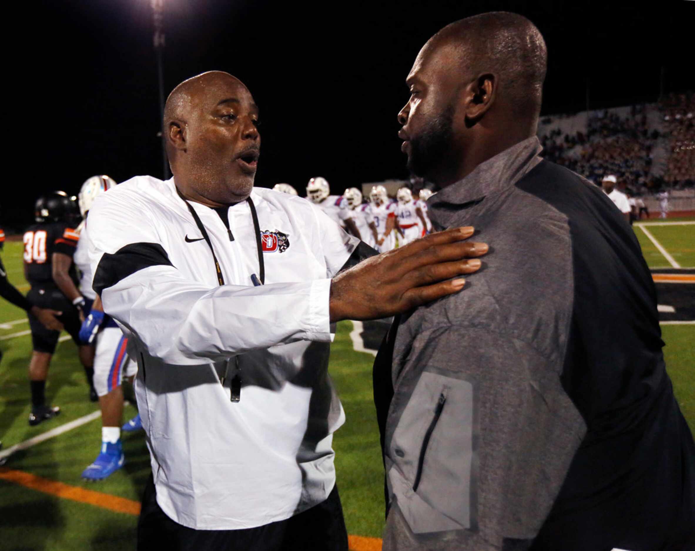 Duncanville head coach Reginald Samples (left) is congratulated by Lancaster head coach...