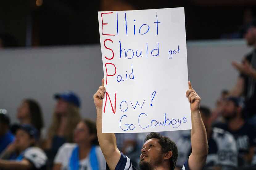 Un fan sostiene un cartel que dice 'Elliott debe ser pagado ahora. Vamos Cowboys', el jueves...