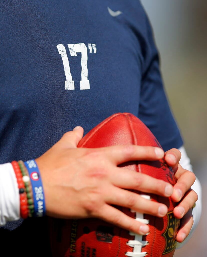A Dallas Cowboys ballboy wears one of the inspirational 17" t-shirts during afternoon...