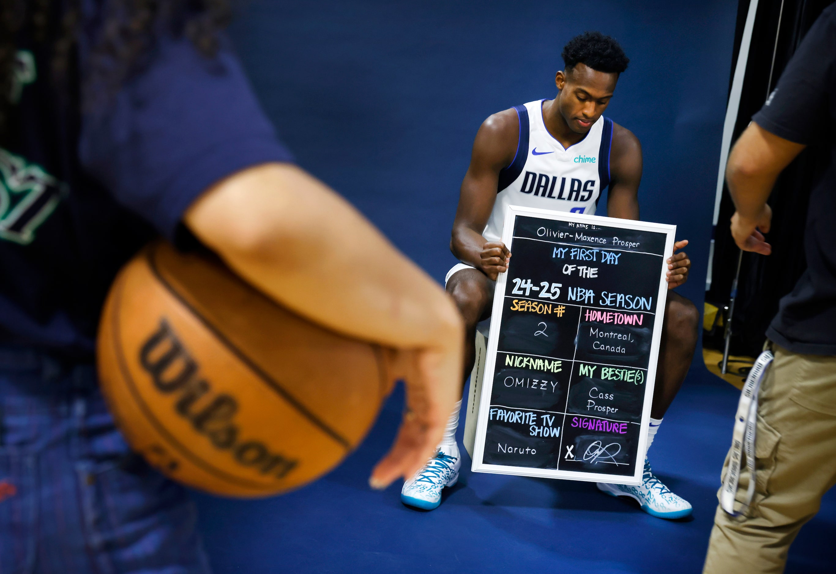 Dallas Mavericks Olivier-Maxence Prosper poses with a chalkboard highlighting things about...