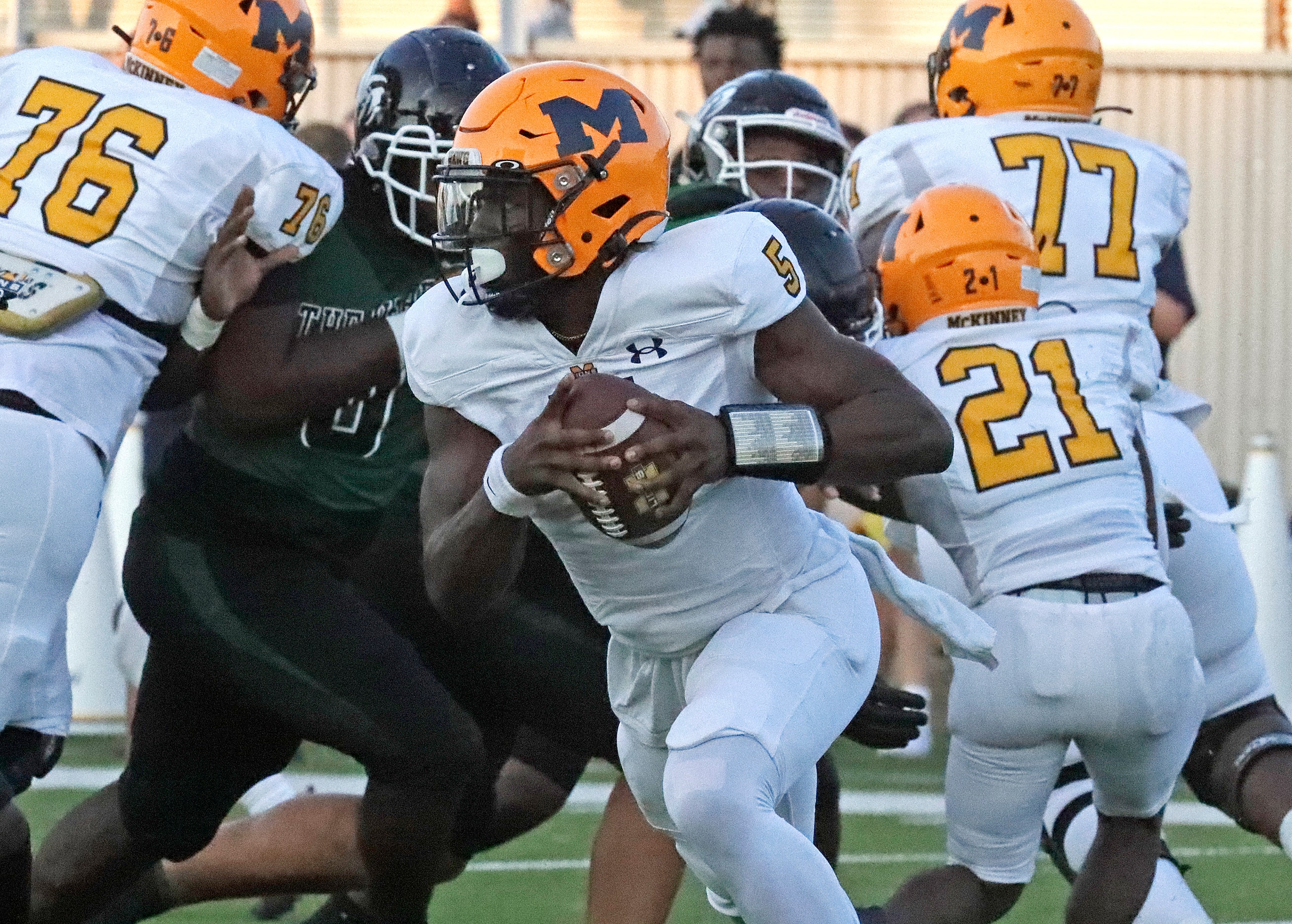 McKinney High School quarterback Godspower Nwawuihe (5) rolls out during the first half as...