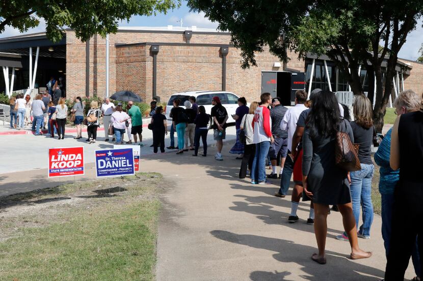 People wait in line to vote early at Fretz Park Dallas Public Library in Dallas on Monday,...