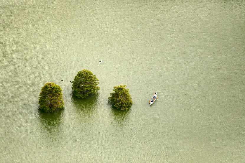 Paddlers in a canoe make their way through a flooded lake in Houston, Texas, Wednesday,...