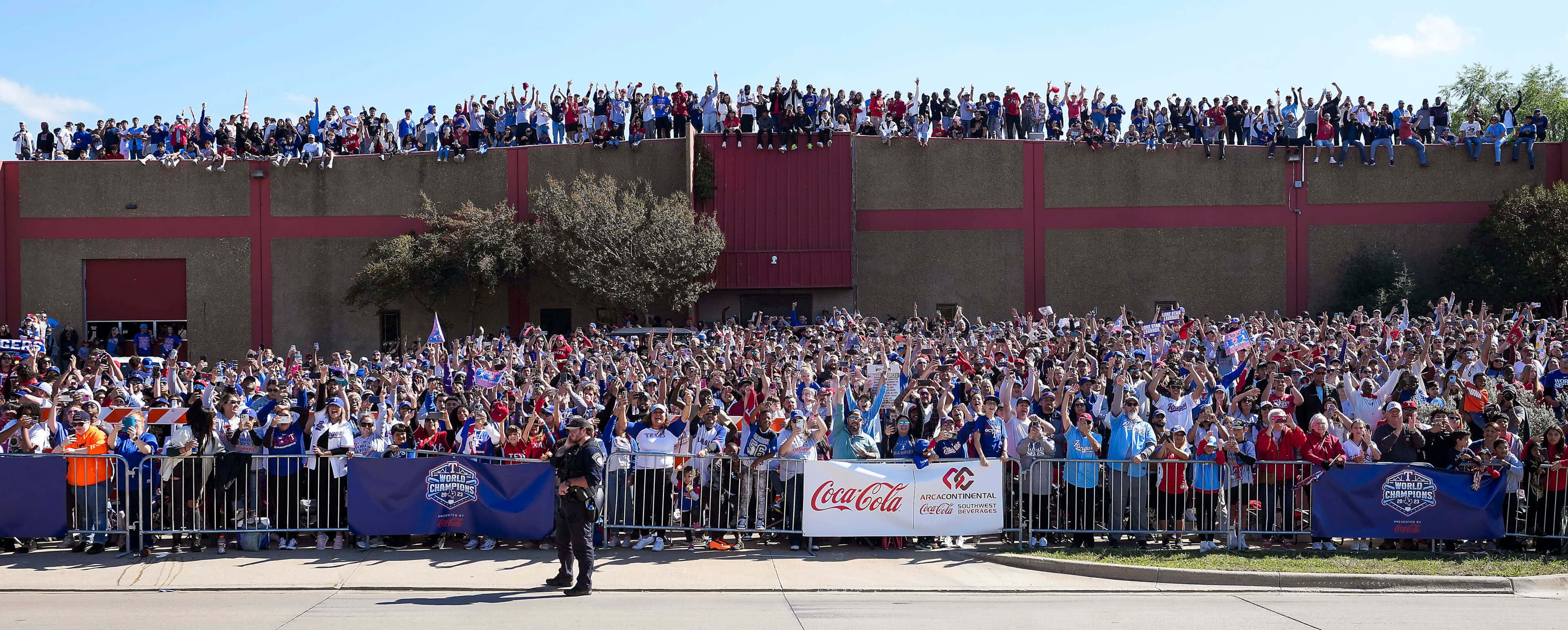 Fans line the parade route and rooftops during the Texas Rangers World Series victory...