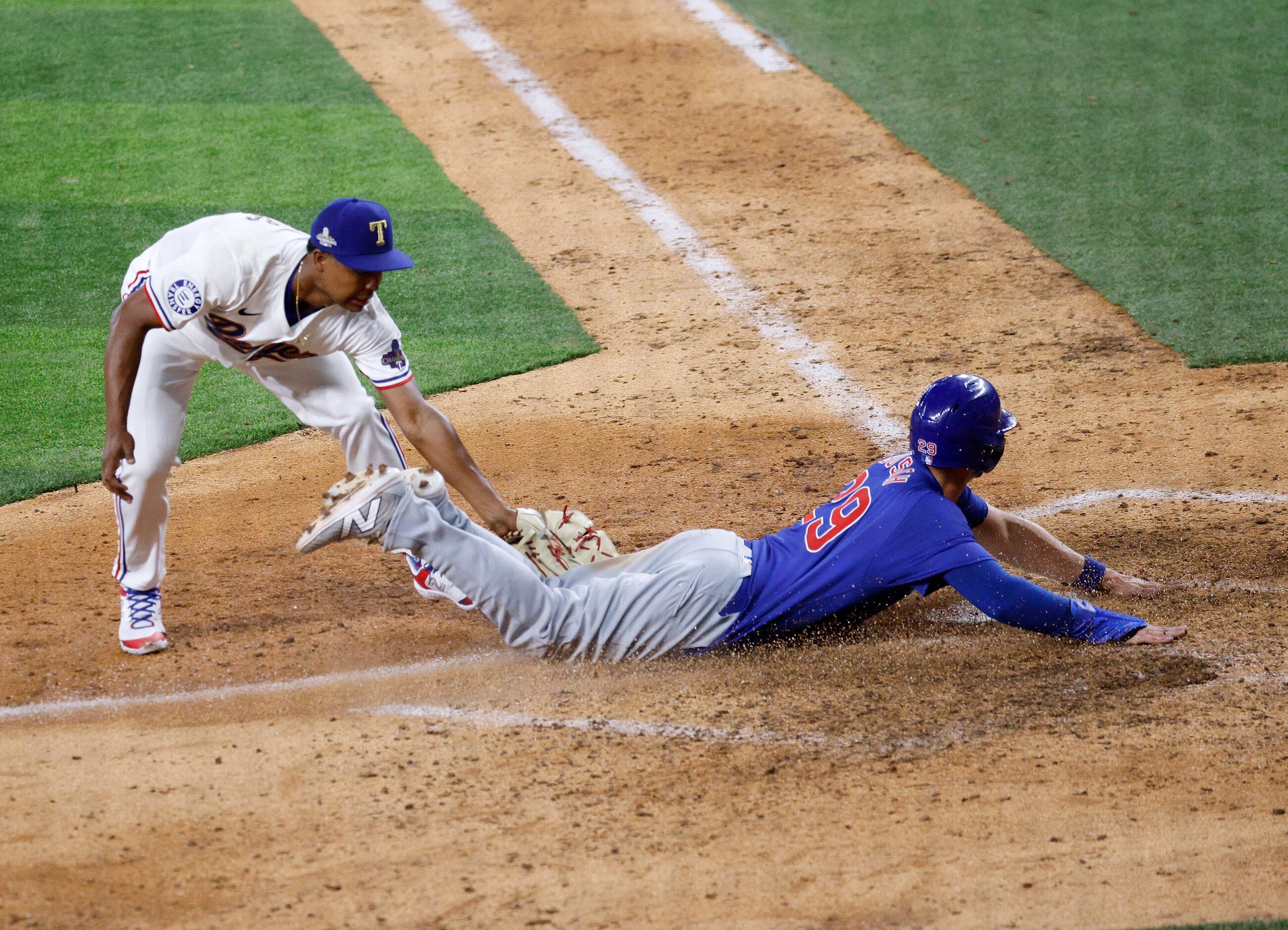 Chicago Cubs third baseman Michael Busch (29) scores on Texas Rangers relief pitcher Jose...