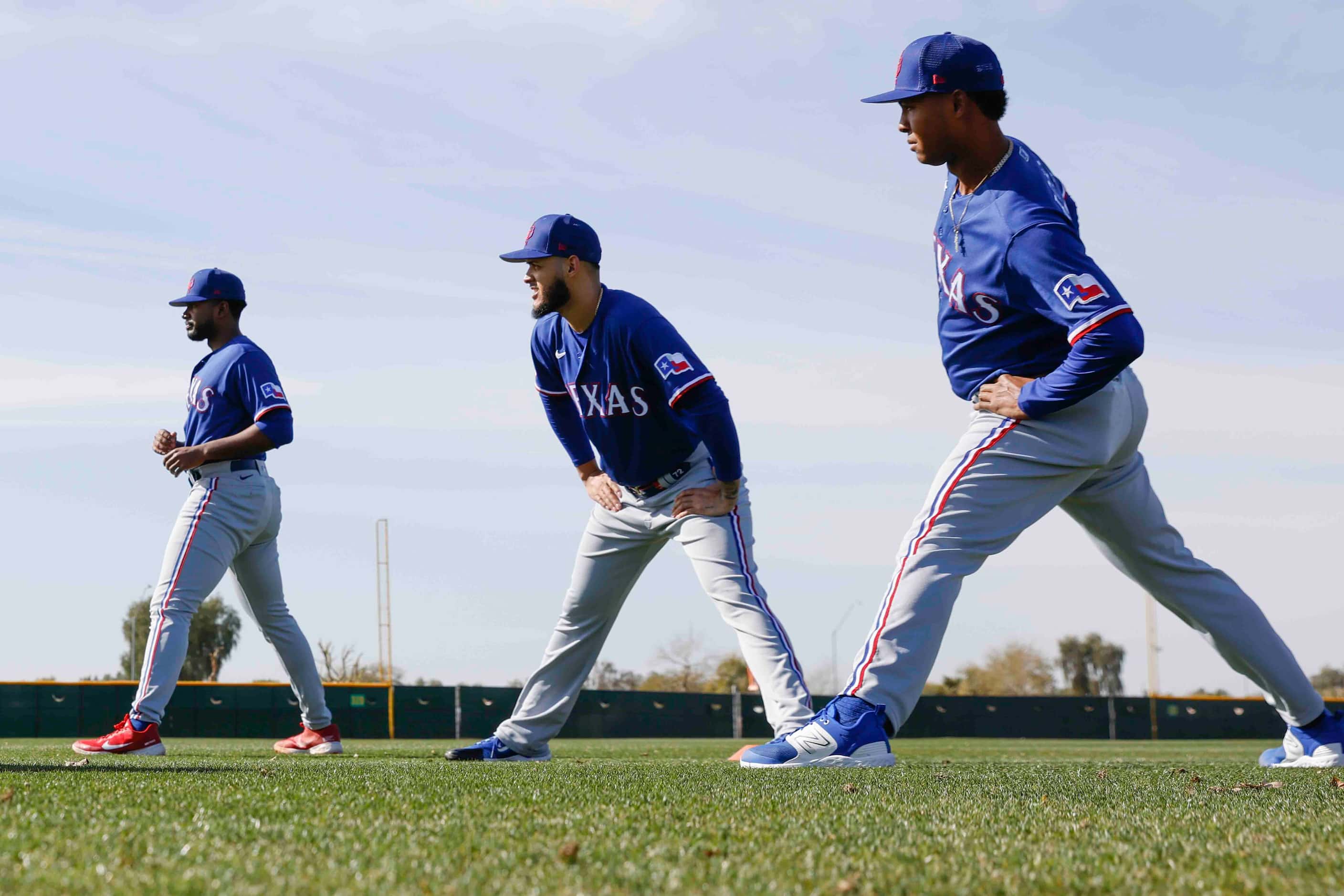 From left, Texas Rangers pitchers Kumar Rocker, Jonathan Hernández, and Jose Leclerc stretch...