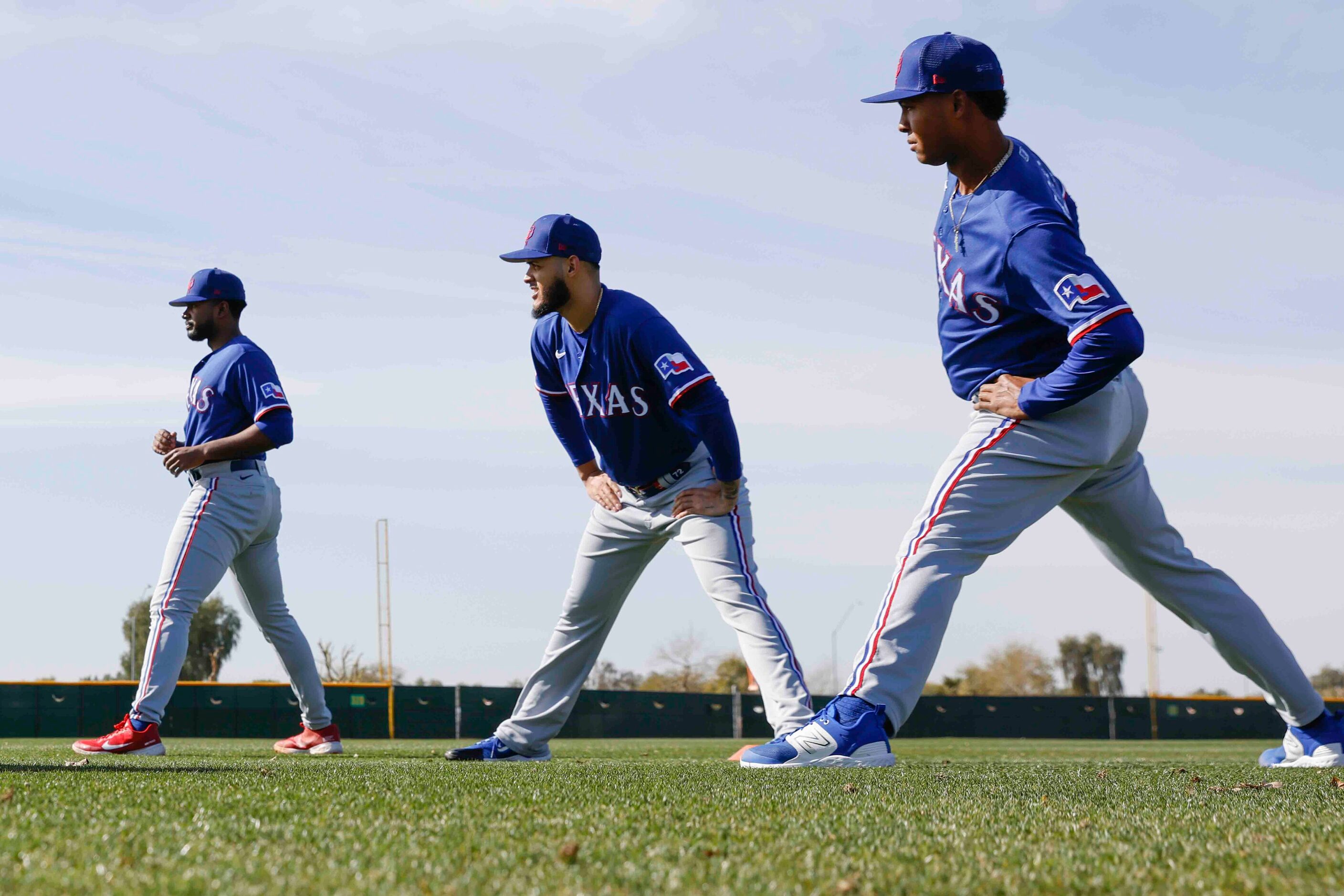 From left, Texas Rangers pitchers Kumar Rocker, Jonathan Hernández, and Jose Leclerc stretch...