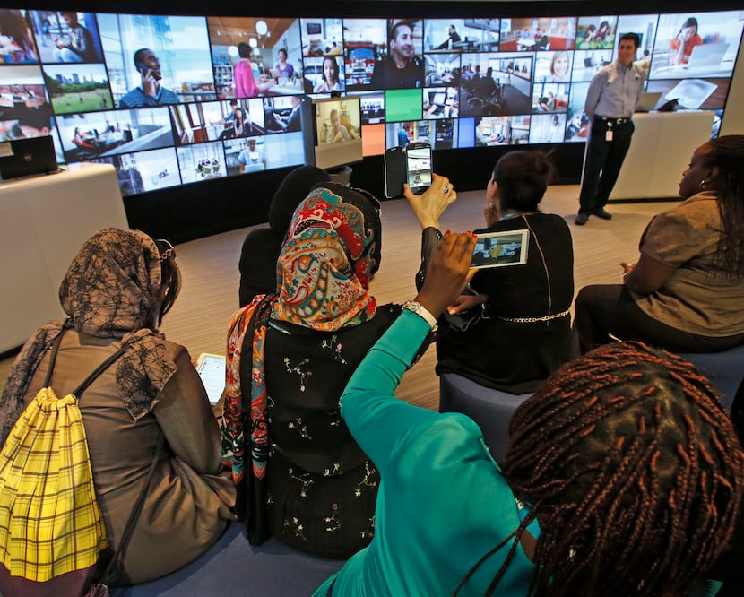 Women from Afghanistan and Rwanda listened to a presentation as AT&T hosted them as part of...