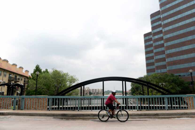 Andre Herron, who lives in the Las Colinas Urban Center, rides his bike around the area,...