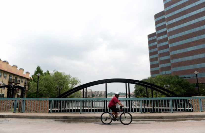 Andre Herron, who lives in the Las Colinas Urban Center, rides his bike around the area,...