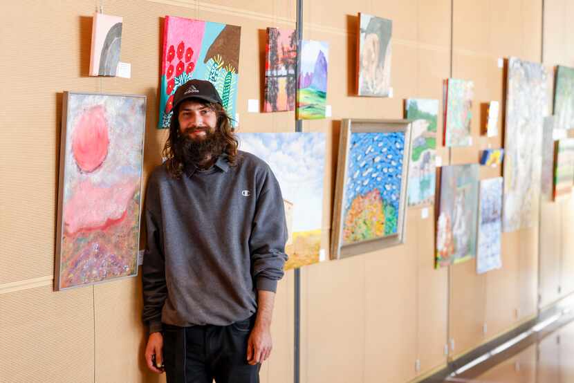 Craig T. Baker poses for a photo by his artwork, Valley, during an art exhibition made by...