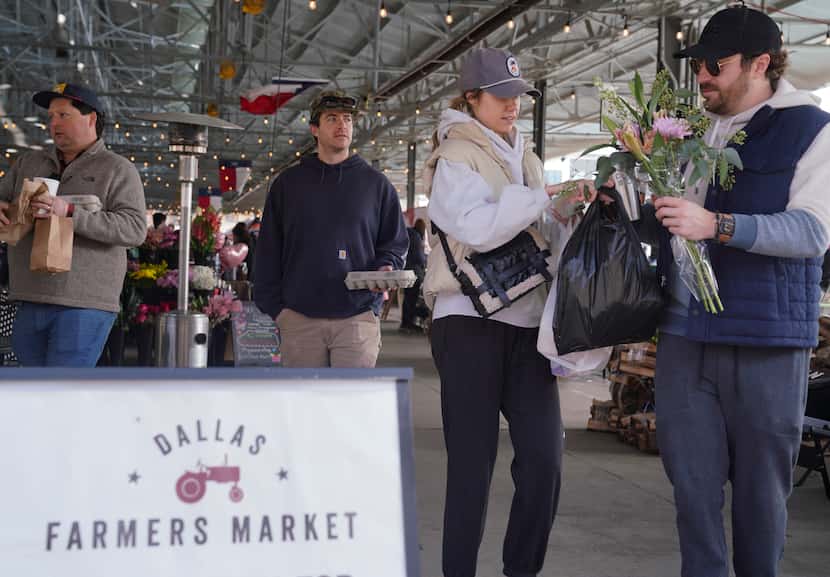 Molly McCarthy hands groceries to Billy Humphrey in The Shed at the Dallas Farmer’s Market...