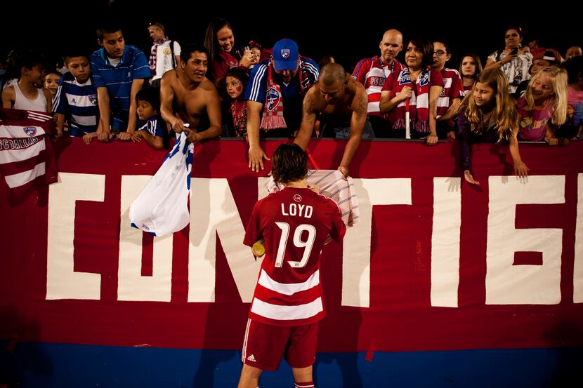 FC Dallas defender Zach Loyd (19) signs autographs for fans after the game against the...