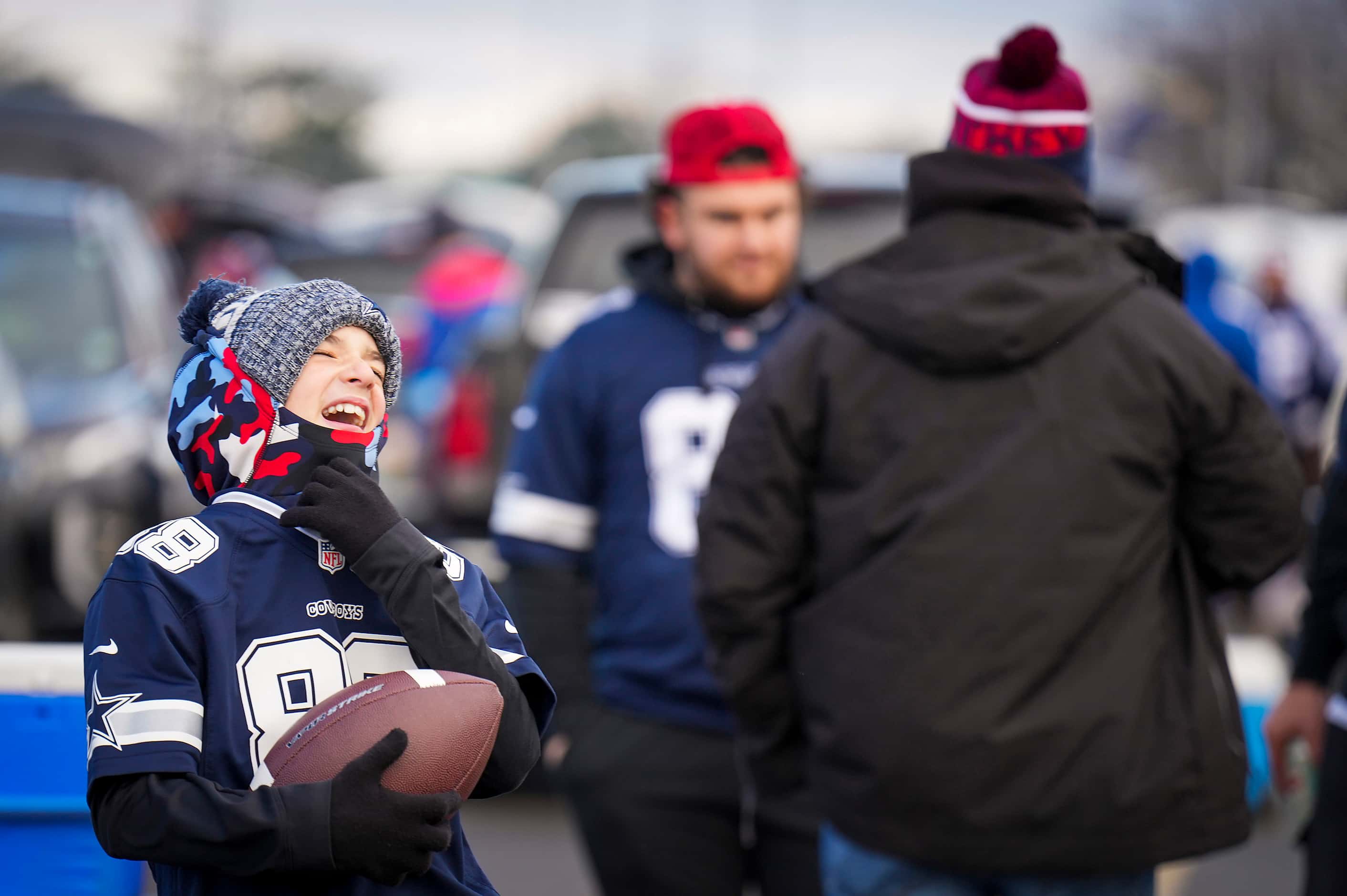 Dallas Cowboys fan Pio Carotenuto laughs while tossing a football with his cousin tailgating...