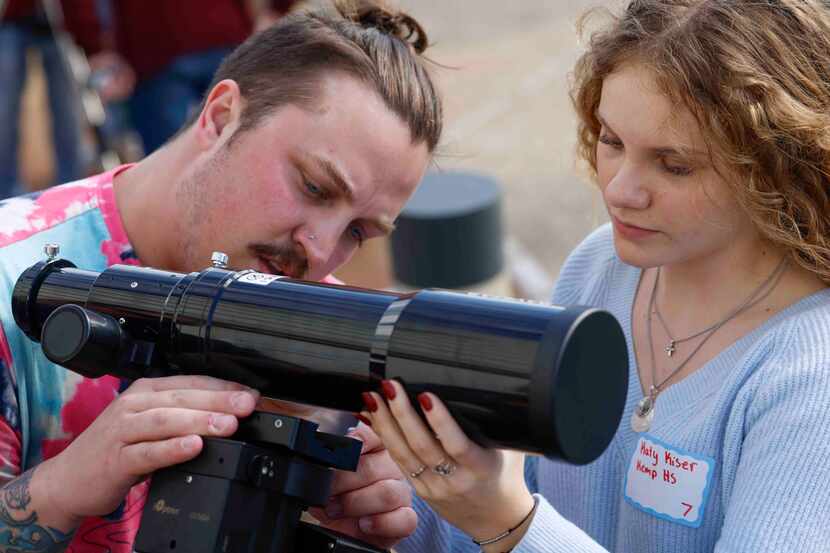 Billy House and Katy Kiser (right) of Kemp High School, set up a telescope during a training...