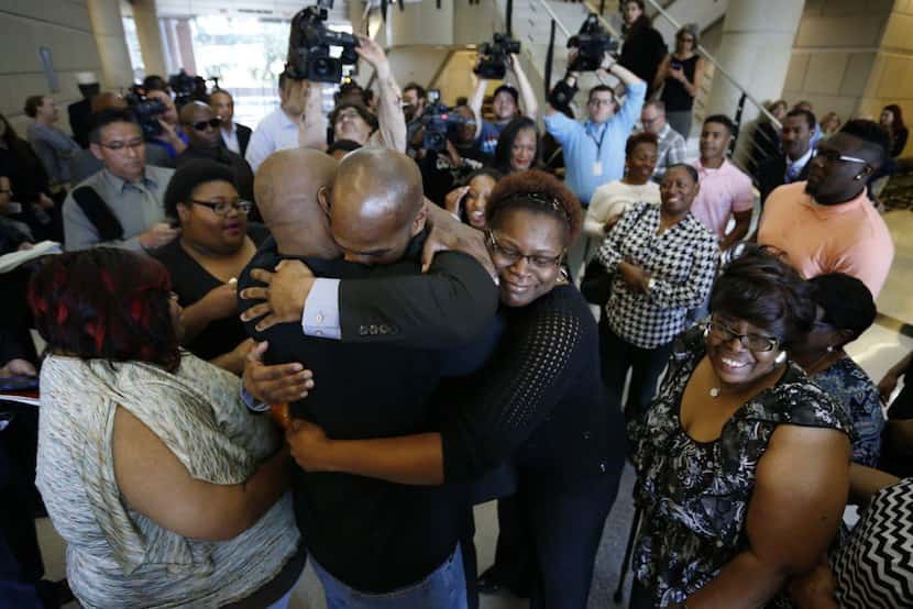 John Nolley (center, facing camera) was embraced by his brother LaMarcus Nolley and sister...