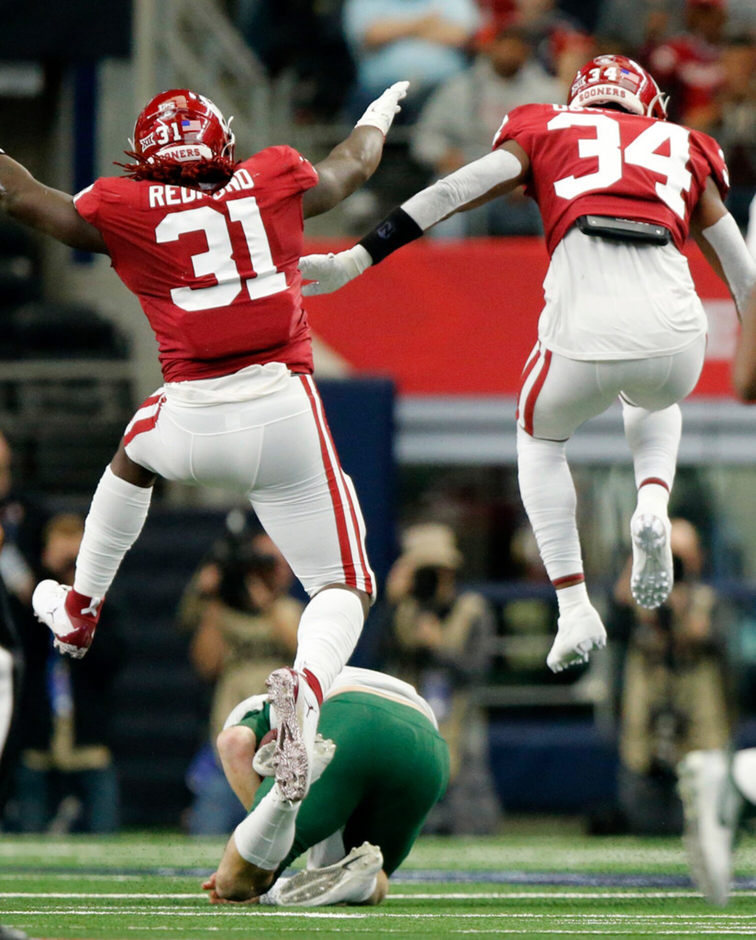 Oklahoma Sooners defensive tackle Jalen Redmond (31) and safety Eric Gallegos (34) celebrate...