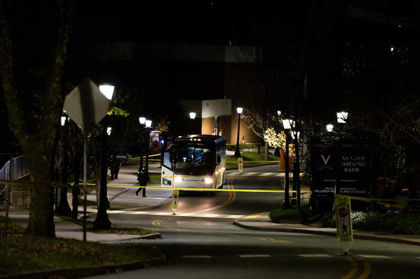 A bus idles behind police tape during an active shooter situation at the University of...