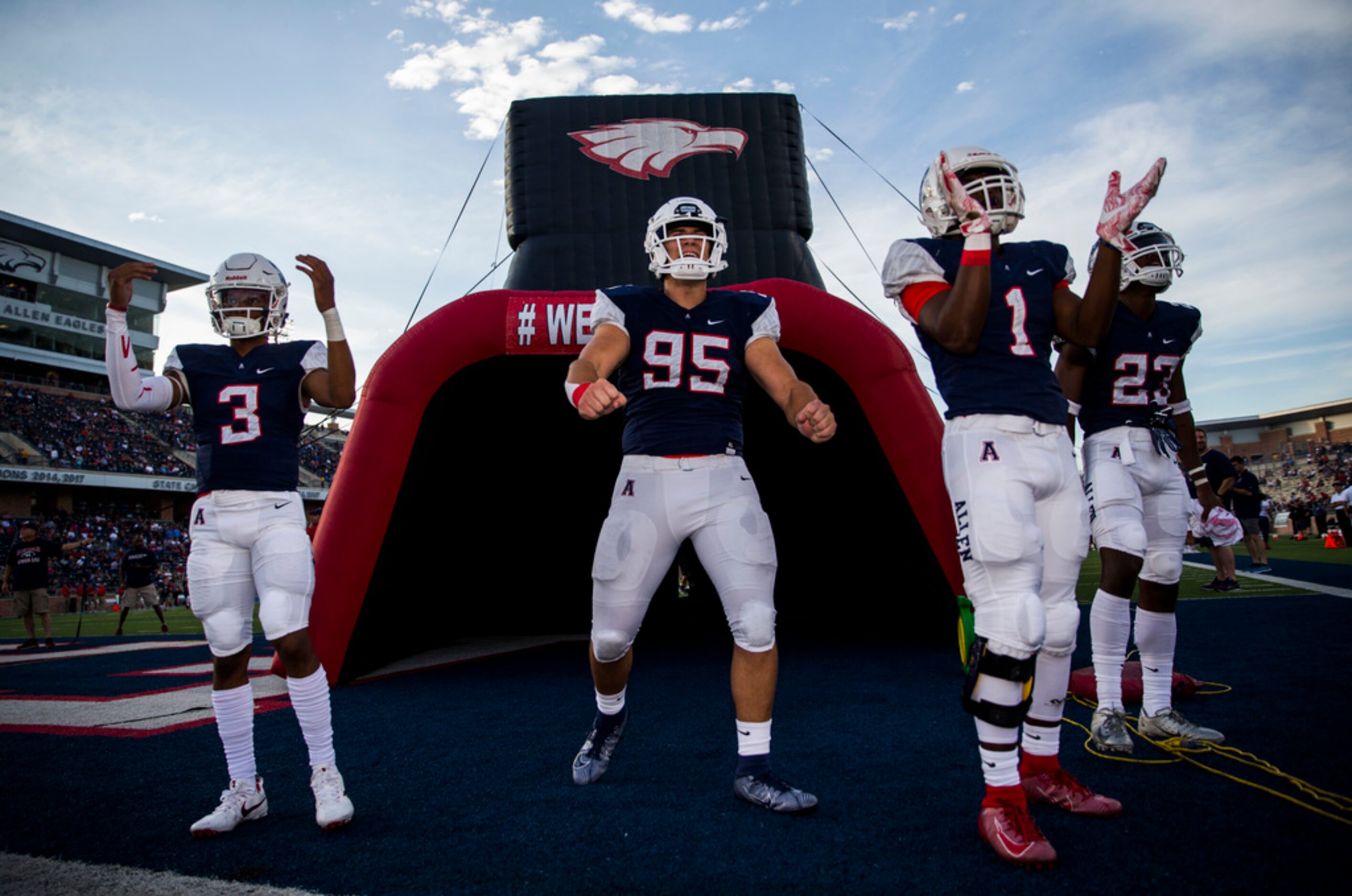 Allen football players cheer on their team before a high school football game between Allen...