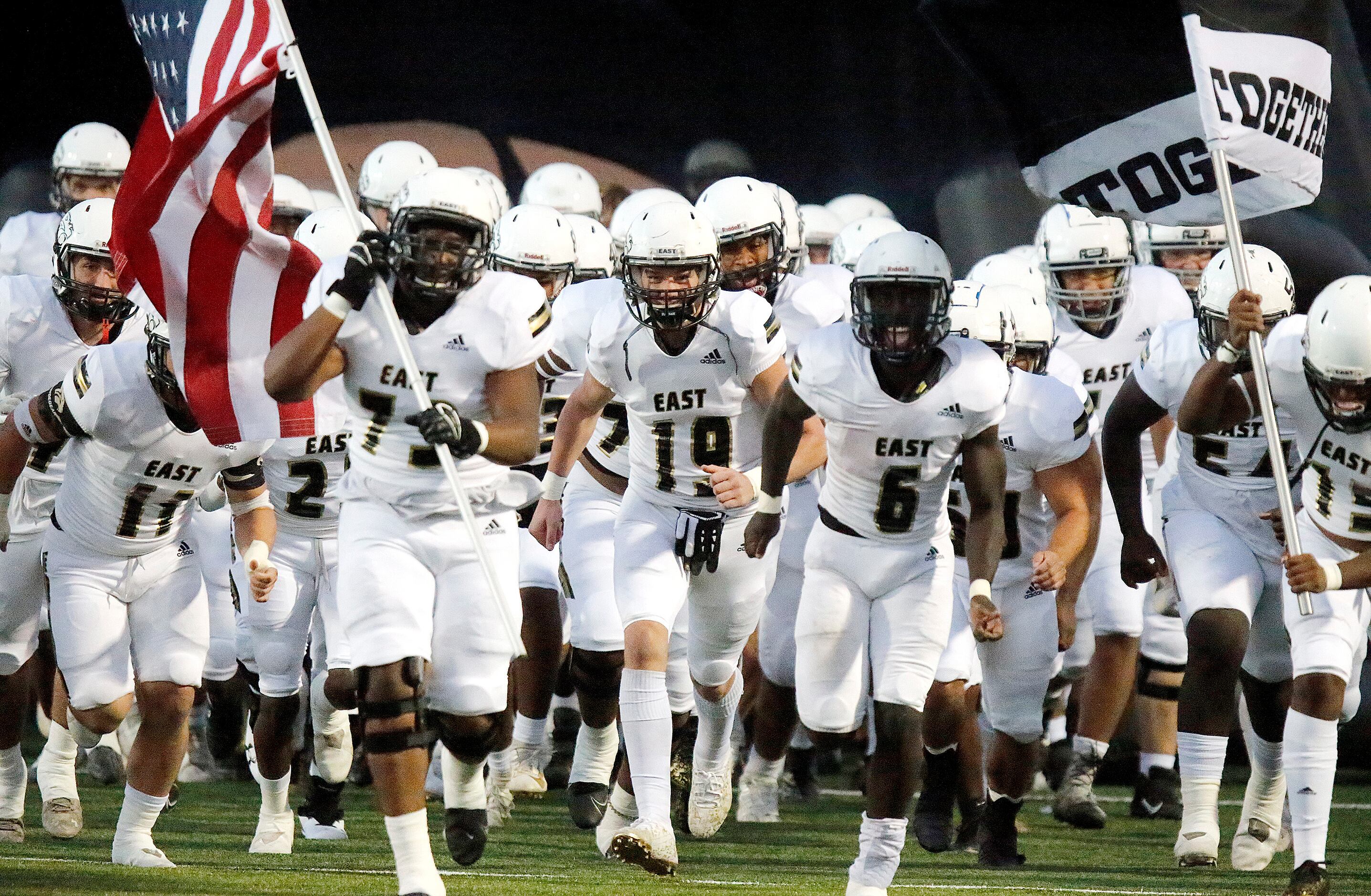 Plano East High School runs onto the field before kickoff as Flower Mound High School hosted...