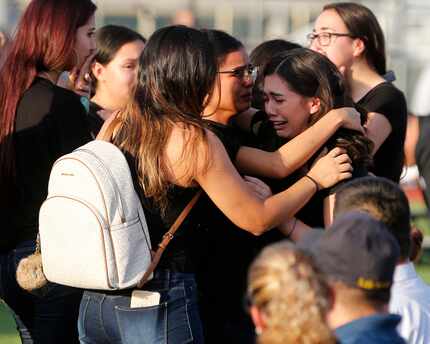 People hug the family of Javier Amir Rodriguez prior to the start of a memorial at Horizon...