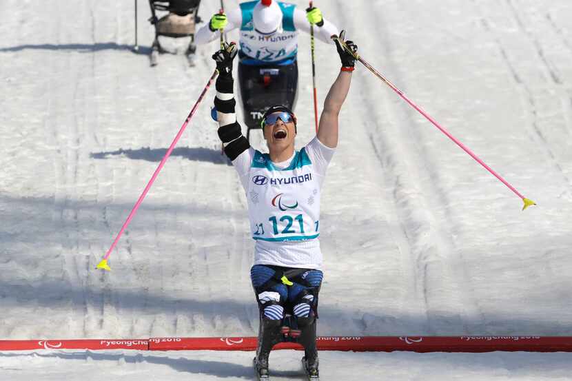 Gold medal winner Oksana Masters of the United States celebrates as she crosses the finish...