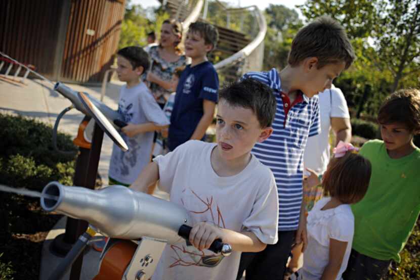 Henry Kern (center), 7, fires a water cannon as he and other students from Heritage School...