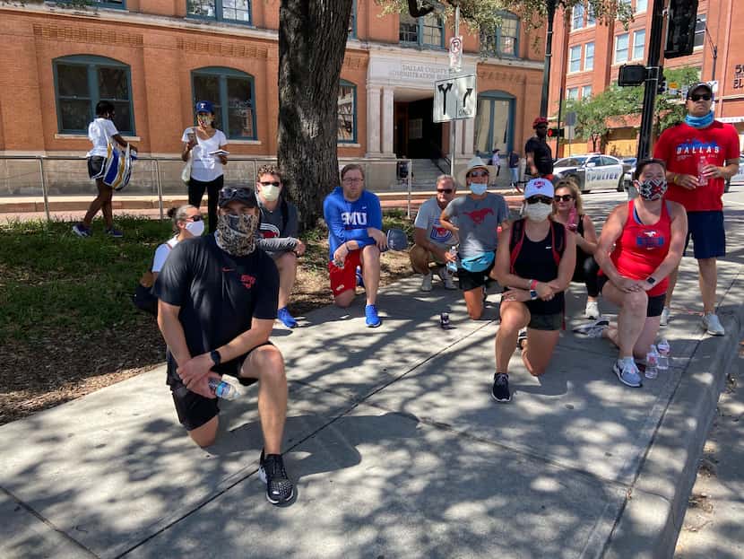 SMU staff members kneel in support of protesters near Dealey Plaza on June 5, 2020. (By Sam...