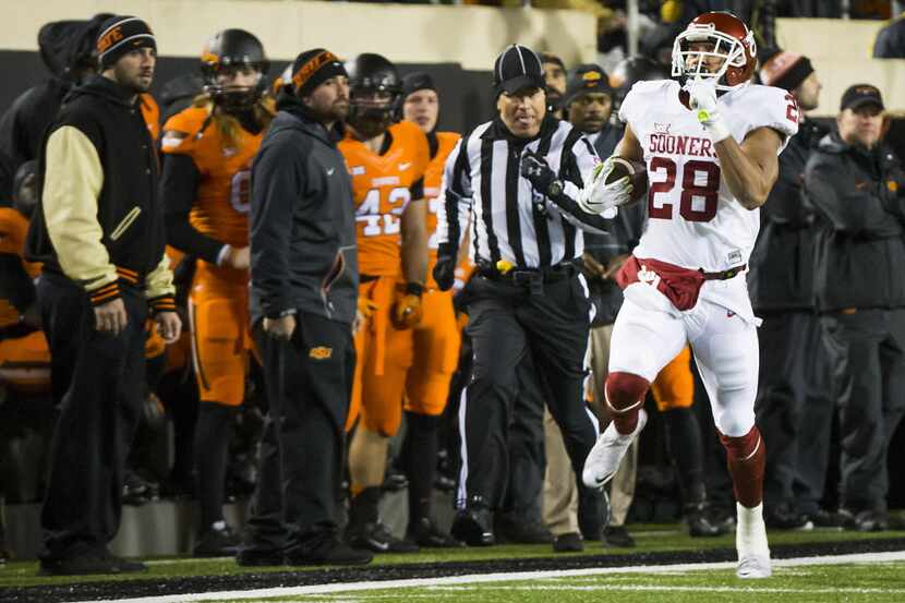 Oklahoma's Alex Ross races down the sidelines as he returns a kickoff 90-yards to set up a...