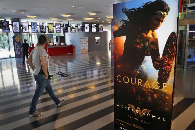 Un hombre pasa junto a un poster promocional de la película "Wonder Woman" ("Mujer...
