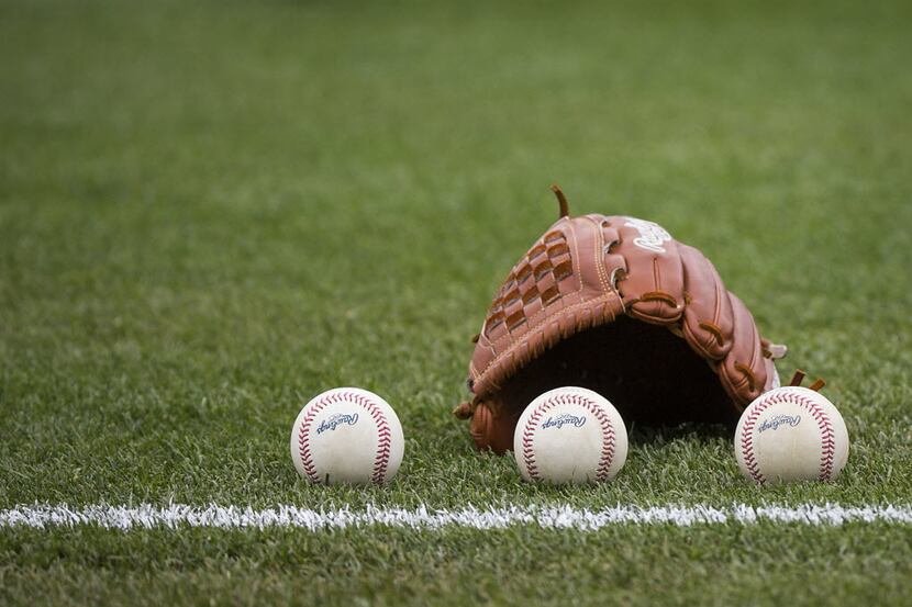 Balls rest next to the glove of Texas Rangers pitcher Nick Tepesch as he warms up before a...