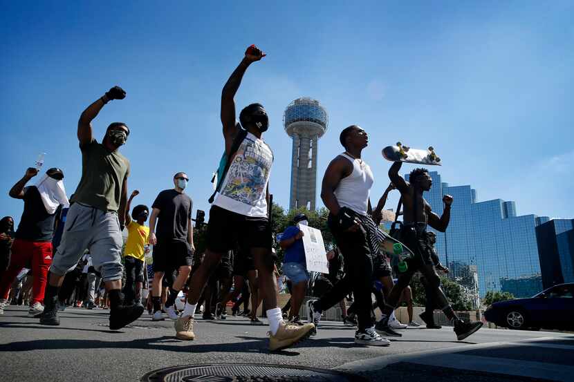 Protesters supporting Black Lives Matters rally march past Reunion Tower on their way to...