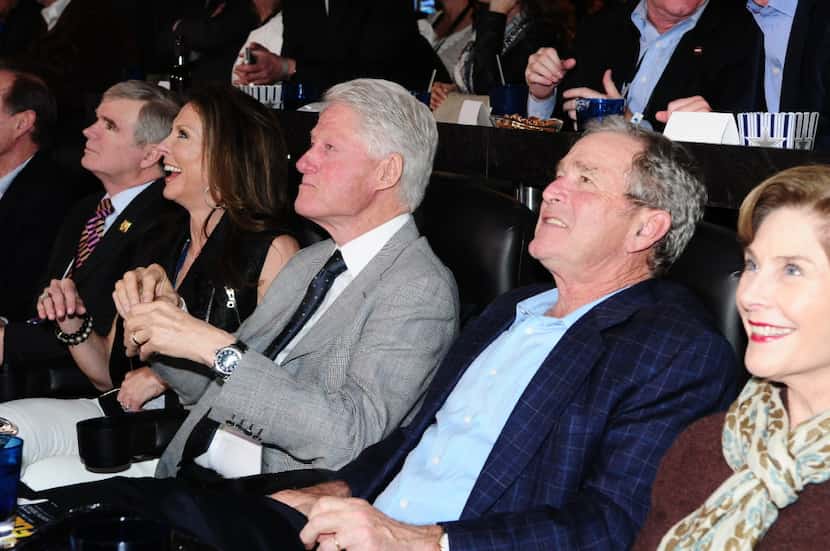 Presidents Bill Clinton and George W. Bush watch a Final Four game in Jerry Jones' suite at...