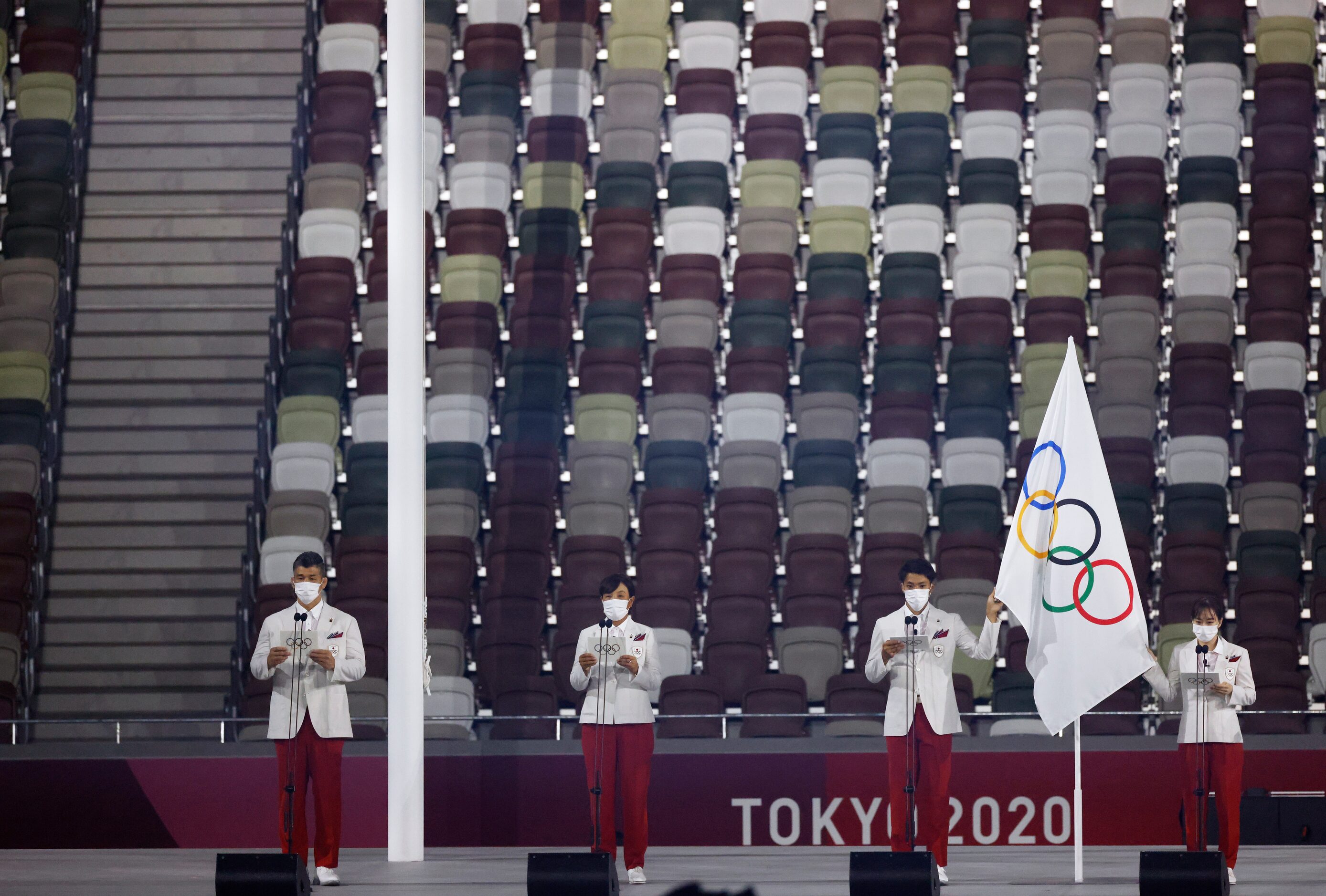 People recite the Olympic pledge during the opening ceremony for the postponed 2020 Tokyo...