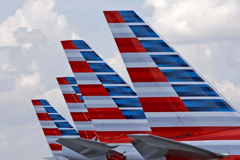  This 2015 photo shows the tails of four American Airlines planes parked at Miami...