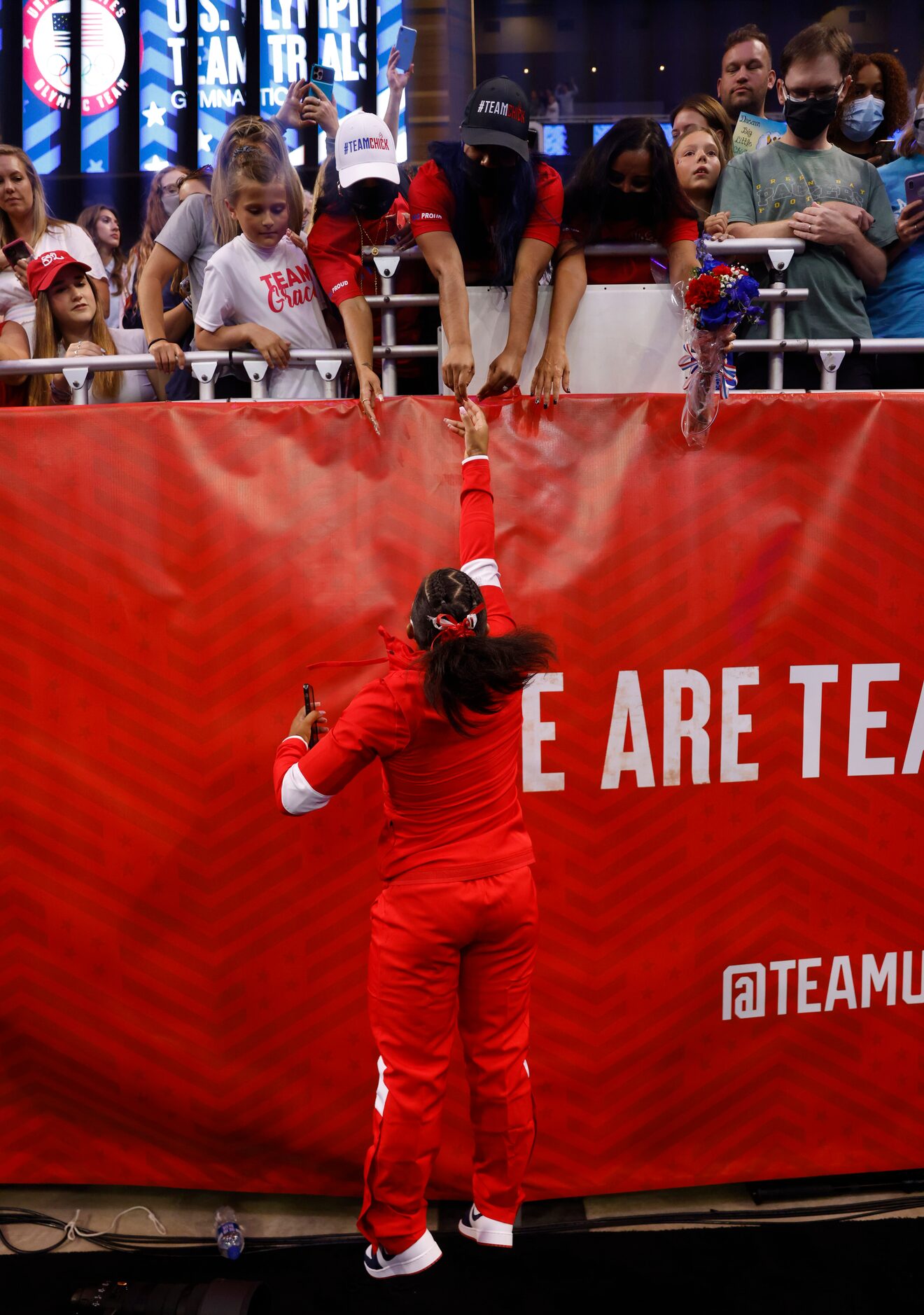 Jordan Chiles tosses flowers to her family after team announcements on day 2 of the women's...