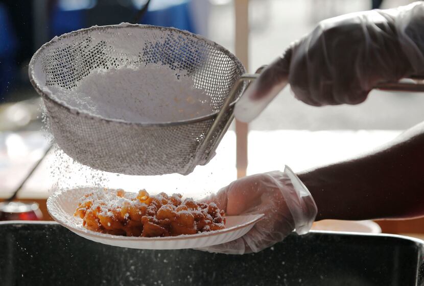 Sheridon Dennis of Chef Cassy's Funnel Cakes powders a funnel cake at Taste of Dallas  2014.