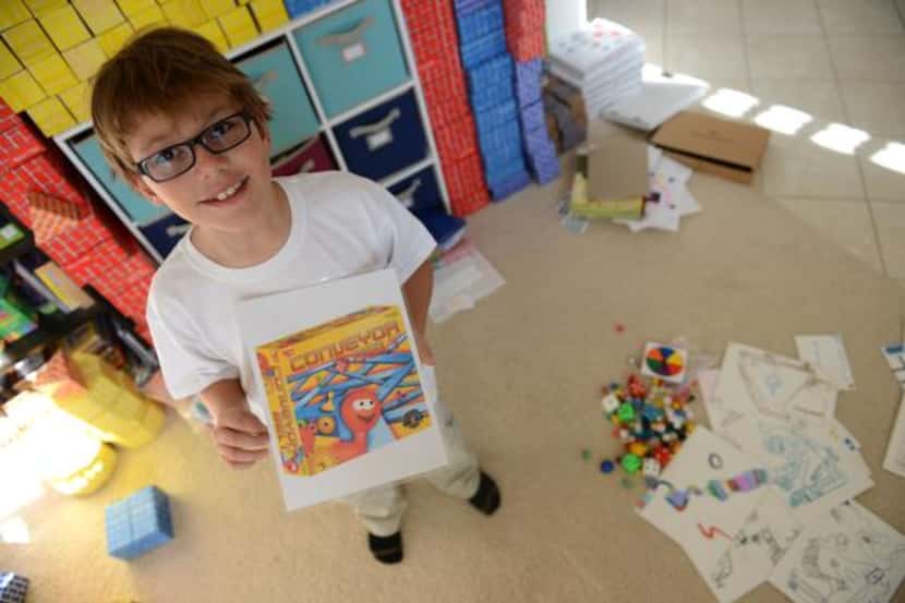 
Franklin Wright, 8, holds the board game he created, Conveyor Belt, at his Frisco home on...