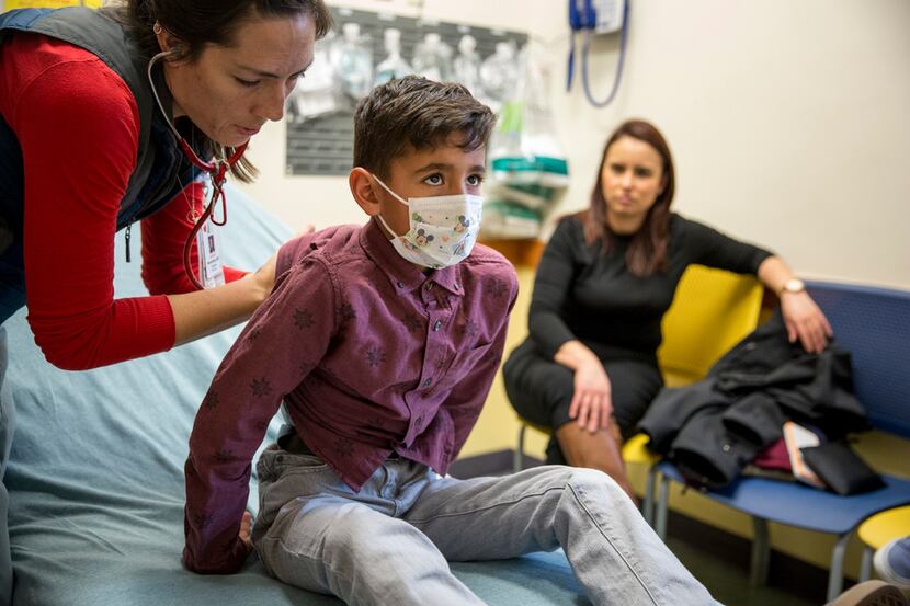 A doctor examines Christopher Serrano, 10, who is covered by the Children's Health Insurance...