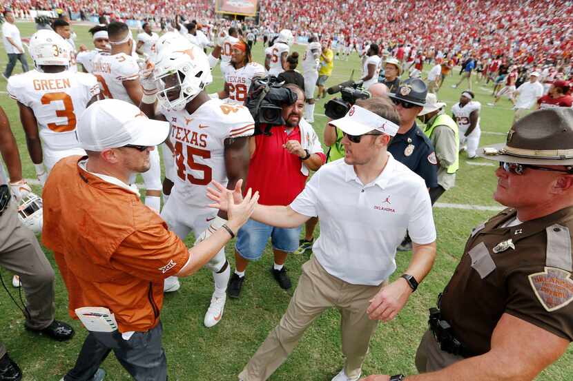 Texas Longhorns head coach Tom Herman and Oklahoma Sooners head coach Lincoln Riley greet...