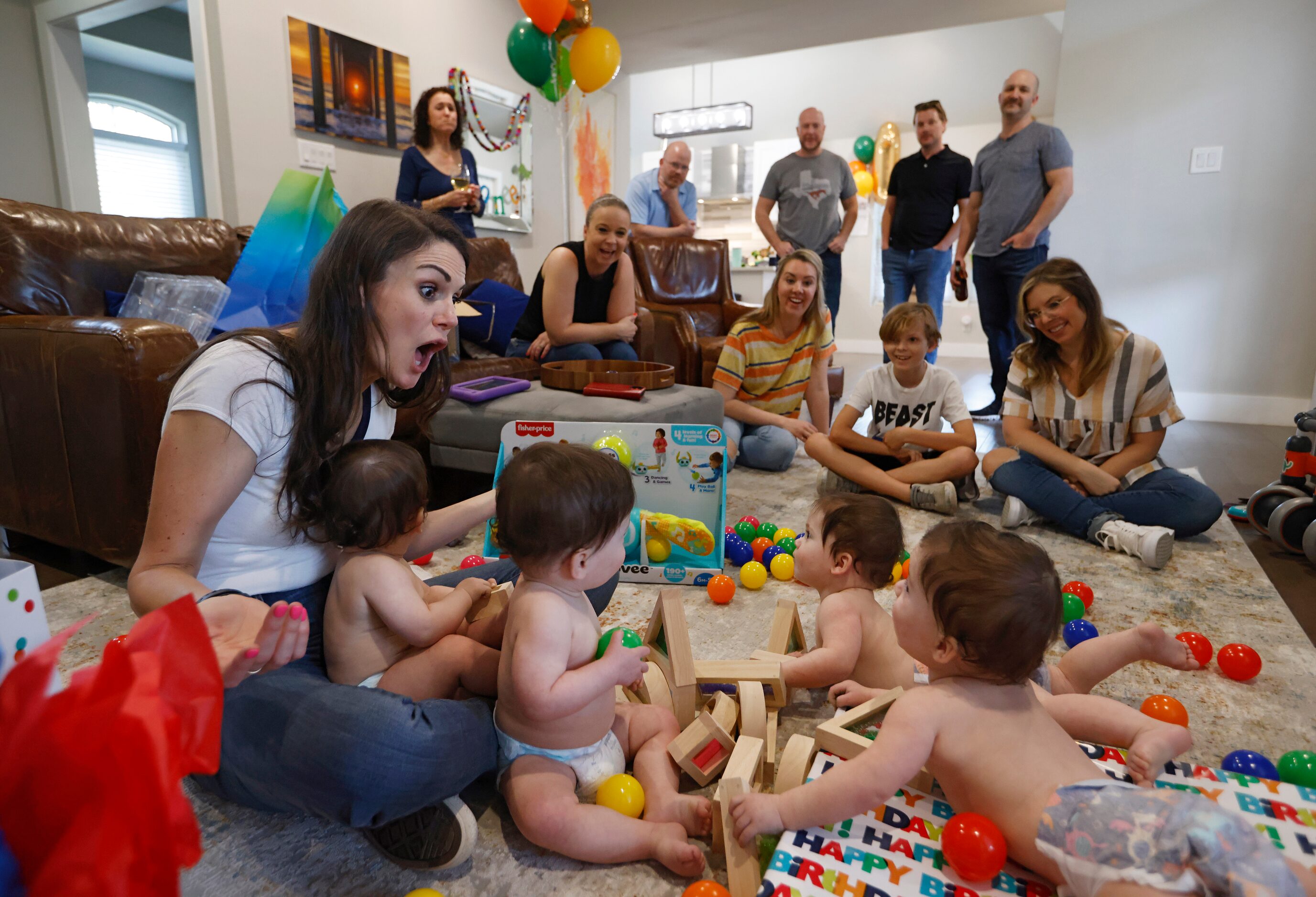 Jenny Marr helps open gifts for Harrison, Hardy, Henry, Hudson Marr as friends and family...