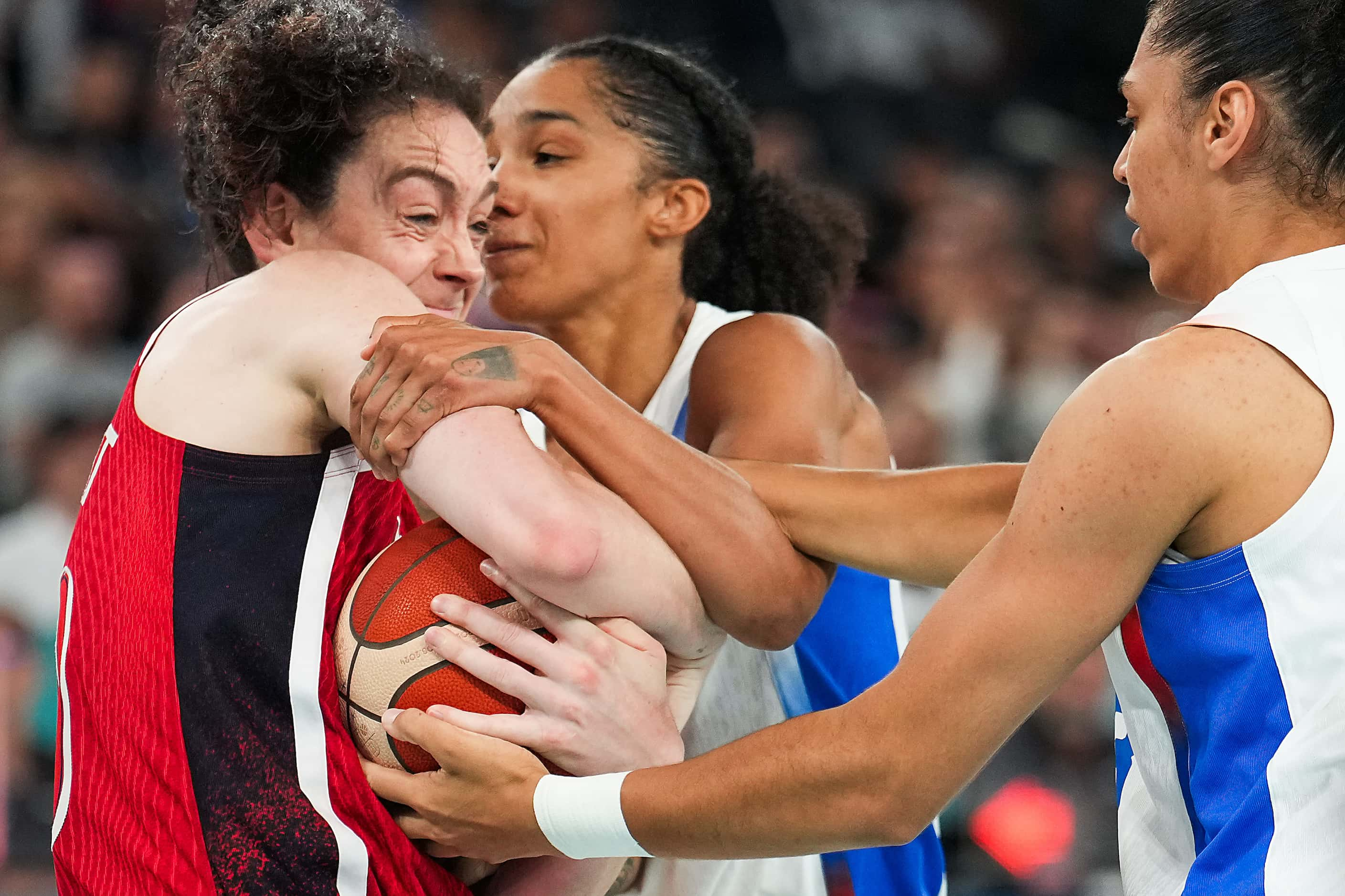 Breanna Stewart (10) of the United States wrestles for the ball with Gabby Williams (center)...