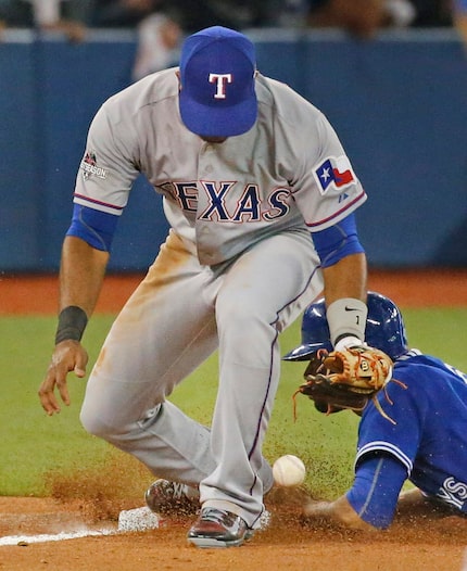 Texas Rangers shortstop Elvis Andrus (1) commits and error while dropping the throw to third...