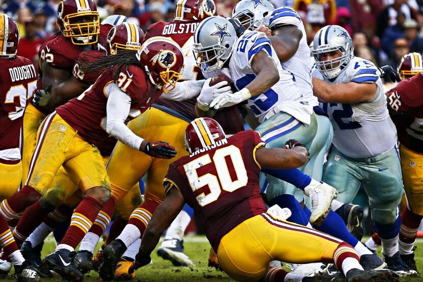 Dallas Cowboys running back DeMarco Murray (29) fights off a tackle by Washington Redskins...