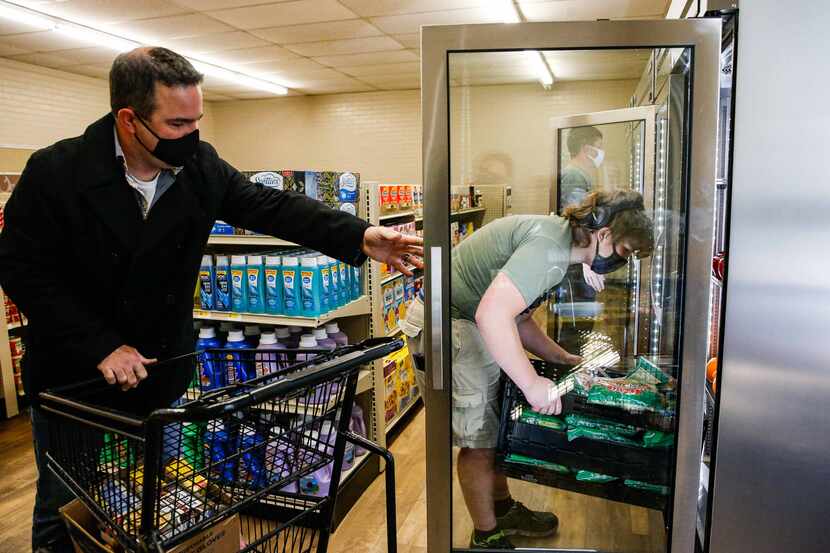 Linda Tutt High School principal Anthony Love helps Preston Westbrook stock a freezer at the...